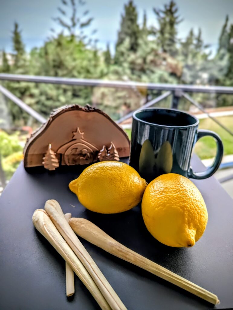 lemons, lemongrass stalks, mug of lemongrass ginger alcohol free blast with nativity scene in the background sober socials spain